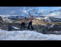 Two shirtless men dances snowy cliff edge