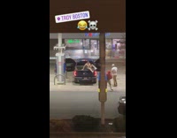 Two Guys Stand on Pickup Truck for Photo at Gas Station