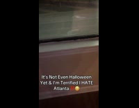 Scary clown staring back at woman