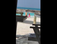 Red wig pink sequined skirt on beach