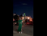 Woman dressed as green inflatable air dancer