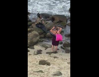Woman scales black mermaid sit rocks beach