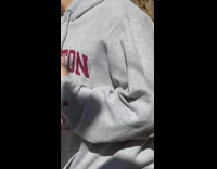 Girl photographs salad bowl by wood wall 