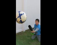 Kid plays with leaf blower and ball