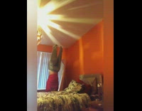 Girl wears sweatpants and red sweatshirt on opposite sides, flips over bed and hits nightstand