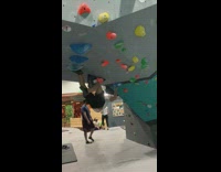 Guy bouldering at rock climbing gym