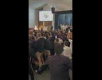 Group of boys dancing jumping to song in auditorium 