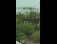 Two men stand on roof during storm