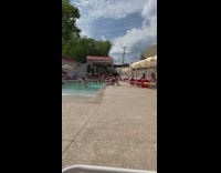Woman in bikini bends on top of the fountain jet