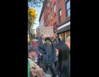 Man dances with poppers signage at marathon