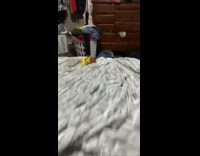 Mom pretends to shoot baby on bed 