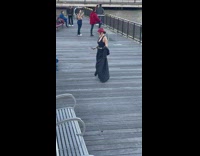 Woman in black coat and red beret tiktok on the dock