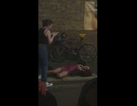 Woman in leather dress lie down the sidewalk