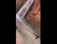 Girl poses in front of waterfall 
