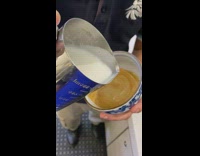 Barista makes coffee art with creamer 