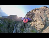 Pink helmet black wingsuit blue parachute waterfall 