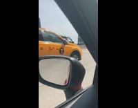 Red van drives on the freeway with side door wide open, white spinning rims