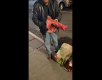 Man pulls out raw meat on street