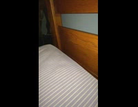 Cat squeezes through crack between mattress headboard 