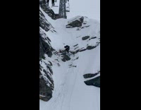 Man with ski board stuck on the rock snowy cliff