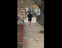 Man goes jogging barefoot and in shorts on sidewalk