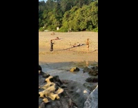 Woman spin hula hoop beach naked guy