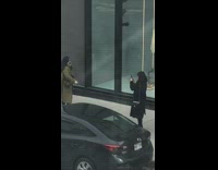 Woman green coat sidewalk phone call