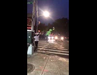 Man crosses the street with inflatable alien on shoulders