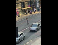 Woman grey shorts jump kick middle of street