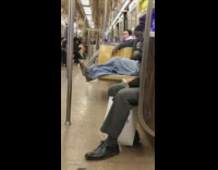 Man smokes and has no shoes on subway train
