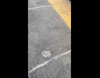 Man with backpack on front outside of moving train