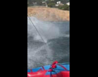 Guy riding single water ski falls