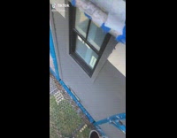 Guy has head in rain gutters of roof 