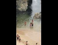 Girl red bikini side pose beach rock