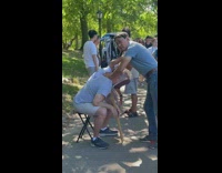 Guy gets massage in chair at park 