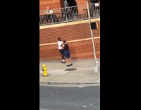 Man video shoot brick wall on sidewalk