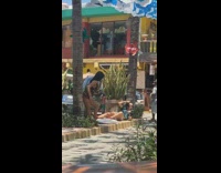 Black romper girl leans against tree trunk 