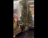 Man outside Christmas tree costume ride train
