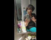 Woman in restroom records herself trying on animated sunglasses