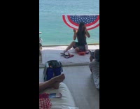 Girl sits by glass railing on boat 