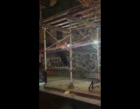 Man works out at scaffolding on street