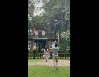 Girl dress hat cameraman hold long tripod