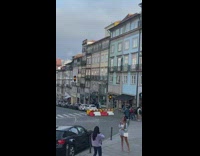 Woman in checkered white dress poses on the sidewalk