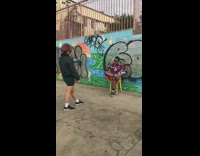 Guy sits yellow chair blue green graffiti