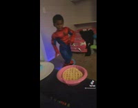 Little boy in spiderman costume walks into room dancing