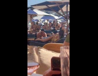 Woman in bikini twerks on beach sunbed