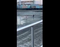 Woman in bikini top poses at boardwalk