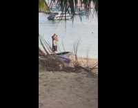 Man in black briefs tiktok dance at the beach