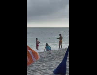 Man in red briefs poses at the beach