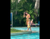 Woman green bikini hold flower walk poolside